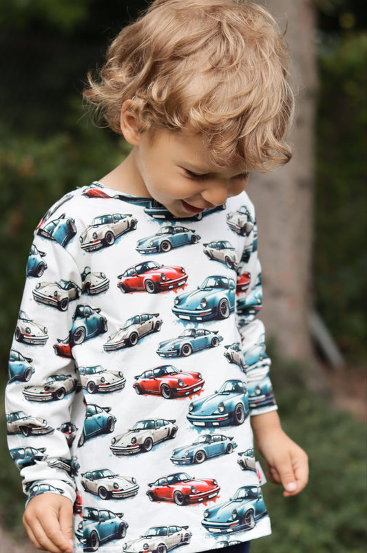 Child wearing a hoodie with car pattern outdoors
