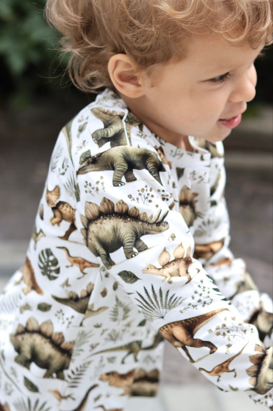 Child wearing a dinosaur-patterned shirt outdoors