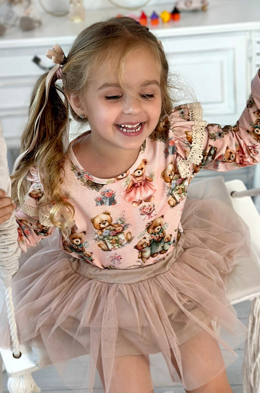 Child sitting on a swing in a room with toys and furniture.